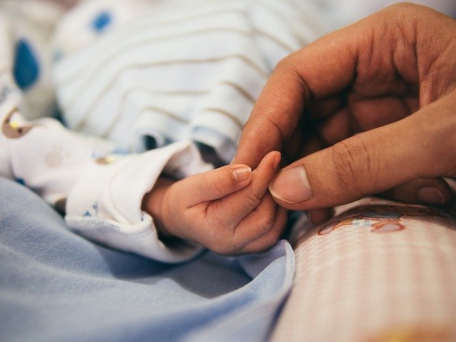 detail ruky rodiče a miminka